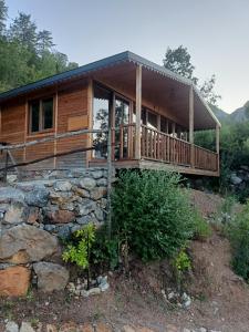 a log cabin with a stone wall at Hergül Holiday Village in Gazipasa +34 photos