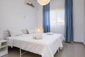 two beds in a white room with blue curtains at Anais Bay Hotel in Protaras +56 photos