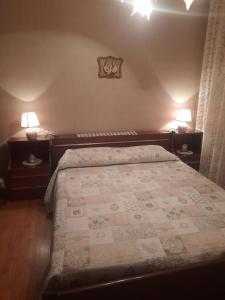 una camera con un letto e due comodini con lampade di Casa vacanze Gianluca ad Aosta