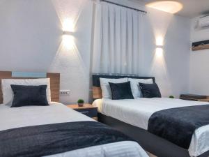 a bedroom with two beds and lights on the wall at Asteris Apartments in Demir Kapija