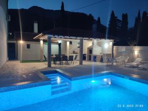 a swimming pool in front of a house at night at Villa Jelena in Trebinje