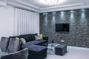 a living room with a couch and a tv on a brick wall at Asteris Apartments in Demir Kapija
