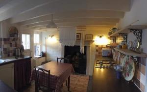 una cucina e un soggiorno con tavolo e bancone di Y Bwthyn Bach - Taff Trail a Treharris