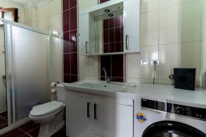 een badkamer met een toilet, een wastafel en een wasmachine bij Hill House in Trabzon