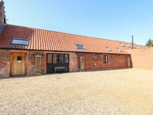 a brick building with a bench in front of it at The Long Barn in Attlebridge