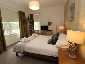 una camera da letto con un letto con una lampada e una scrivania di North Lodge ad Annan