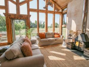 a living room with two couches and a fireplace at The Tractor Shed in Preesgreen