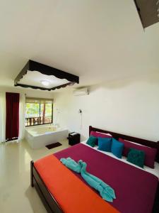 a bedroom with a large bed and a bath tub at Ocean View Lodge in Cahuita