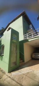 a green and white building with a phone booth at Pousada Colibri in Trindade