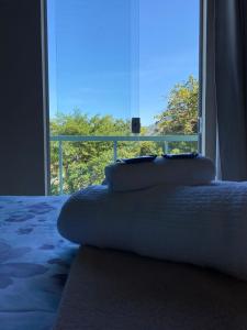 a bedroom with a bed and a large window at Pousada Colibri in Trindade