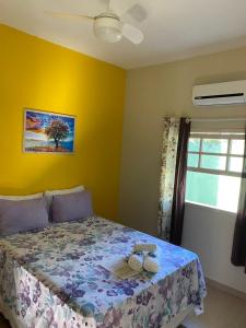 um quarto com uma cama com uma parede amarela em Pousada Colibri em Trindade
