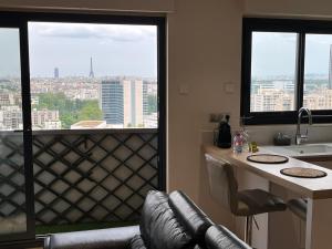 a kitchen with a view of a city from a window at Le Richelieu in Courbevoie