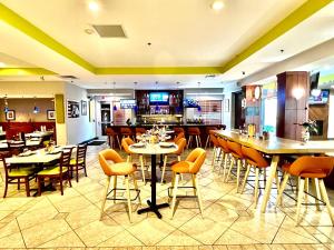 a restaurant with tables and chairs and a bar at Holiday Inn Toledo - Maumee I-80/90, an IHG Hotel in Maumee