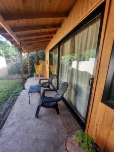 a screened in porch with two chairs and a swing at PINAMARTE in Pinamar