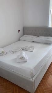 Una cama blanca con un sombrero encima. en Sulaj Sea view 2, en Himare