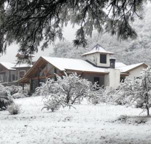 a house covered in snow in front at Fincas del Faldeo in Villa General Belgrano
