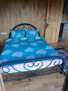 a bed with a blue comforter and blue pillows at Hergül Holiday Village in Gazipasa