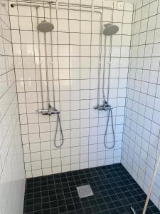 y baño con ducha y 3 mangueras. en Fristad Hostel Vitsand en Gunsjögården