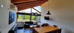 sala de estar con mesa de comedor y ventana en Fincas del Faldeo en Villa General Belgrano