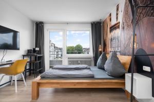 a bedroom with a bed and a desk and a window at Apartment 5, direkt am Bahnhof in Aachen