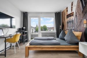 a bedroom with a bed and a desk and a window at Apartment 5, direkt am Bahnhof in Aachen
