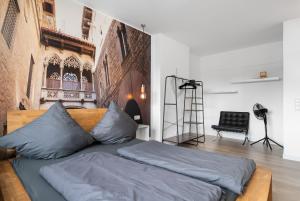 a bed with blue pillows in a room at Apartment 5, direkt am Bahnhof in Aachen
