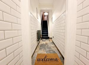 a hallway with a welcome mat on the floor at WhereToStay Cosy 3bed House in Barrow in Furness