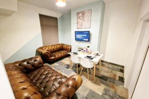 a living room with a leather couch and a table at WhereToStay Cosy 3bed House in Barrow in Furness