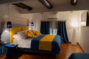 a bedroom with a bed with yellow and blue at Two Rooms Chiaia 37 in Naples
