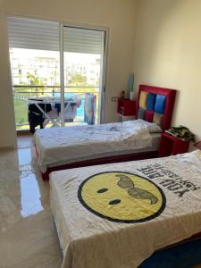 ein Schlafzimmer mit 2 Betten mit einem Bild eines Gesichts in der Unterkunft Appartement à Casabay SidiRahal in Sidi Rahal