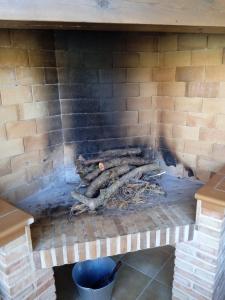 una pila de troncos en una chimenea de ladrillo en CASA RURAL LES ROQUETES, en Ráfales