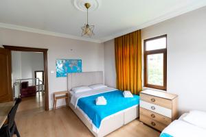 a bedroom with a bed and a dresser and a window at Hill House in Trabzon