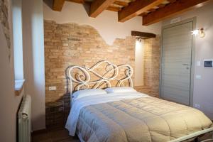a bed in a room with a brick wall at La torre tra terra e cielo in Petritoli