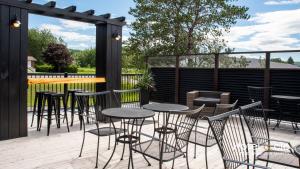 a patio with tables and chairs on a deck at Hôtel & cie in Sainte-Anne-des-Monts