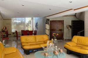 a living room with yellow couches and a table at Casa Berth lu in Oaxaca City
