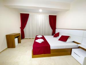 a bedroom with a bed with red pillows on it at Nokta Paspatur Suit Apart, Fethiye, Ölüdeniz in Fethiye