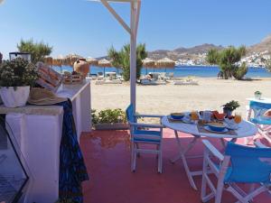 a table and chairs on a patio with a beach at Avlomonasbeach in Livadion
