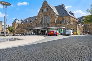 un gran edificio con un reloj al lado de una calle en Apartment 6, direkt am Bahnhof en Aquisgrán