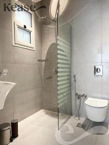 a bathroom with a glass shower with a toilet at Kease Ar Rabi F-7 Luxurious Creativity GX12 in Riyadh