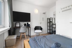 1 dormitorio con 1 cama, escritorio y 2 sillas en Apartment 6, direkt am Bahnhof en Aquisgrán