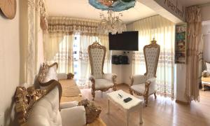 een woonkamer met een bank, stoelen en een kroonluchter bij VERSALLES APARTMENT in Lima