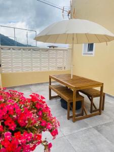 tavolo e panca con ombrellone e fiori di Tierritas Village (Ventanas del Atlántico 2) a Santa Cruz de la Palma