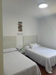 Postel nebo postele na pokoji v ubytování Hostal Los Mellizos