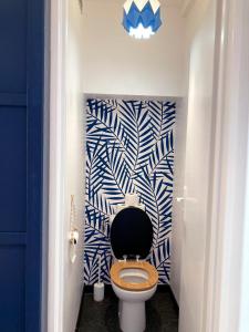 a bathroom with a toilet with a blue and white wall at Studio du vieux port in Quiberon