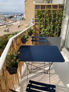 a blue table on a balcony with plants at Studio du vieux port in Quiberon