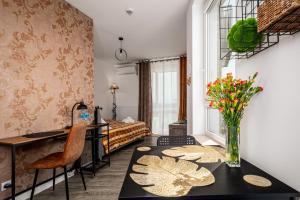 a room with a desk and a table with flowers on it at AYCON APARTMENTS - MODERN SPACE in Warsaw