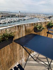 a blue table on a balcony with a marina at Studio du vieux port in Quiberon