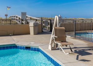 a chair sitting next to a swimming pool at Phoenix All Suites West Hotel in Gulf Shores