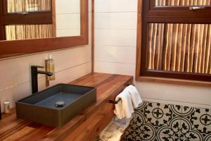 a bathroom with a black sink on a wooden floor at Cuarzo Lodge in Pichilemu +38 photos