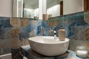 a bathroom with a white sink and a mirror at Two Rooms Chiaia 37 in Naples +29 photos